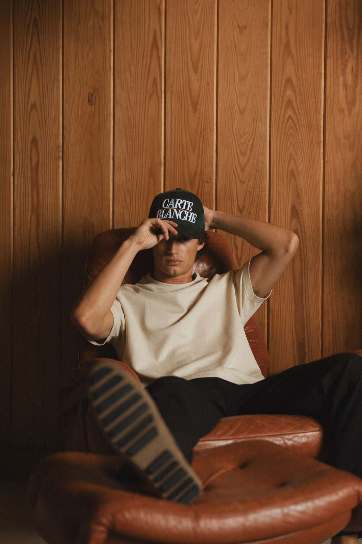 Carte Blanche 013 lifestyle shot — models in cabin setting with cinematic warm lighting and film grain