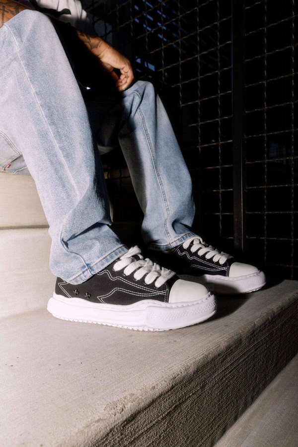 Sneakers and denim on concrete steps, KAGE editorial detail