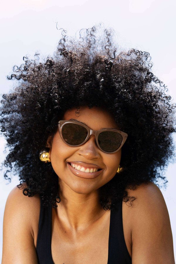Smiling model in sunglasses and gold earrings, Melonz lifestyle shoot