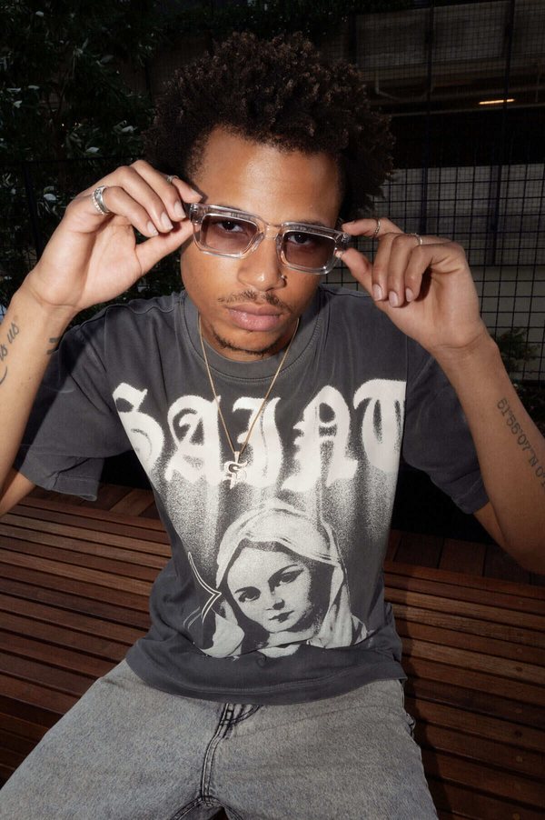 Model in a Saint Potential graphic tee lowering his sunglasses