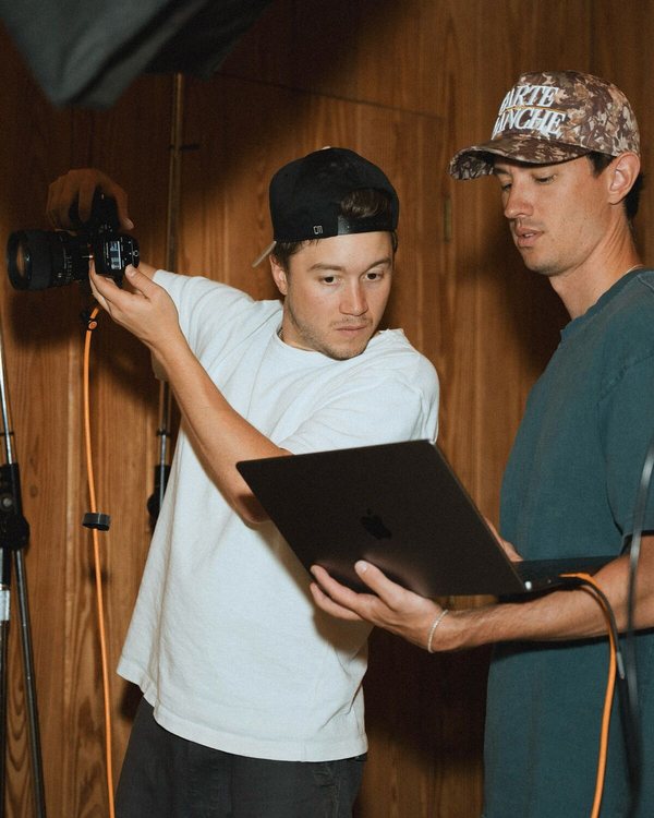 JohnPaul reviewing the shot list on a laptop with the team before a shoot